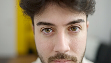 Fototapeta premium Young hispanic man close up of serious expression at home