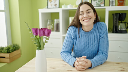 Young caucasian woman smiling confident sitting on table at dinning room