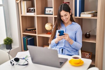 Young woman using smartphone working at home