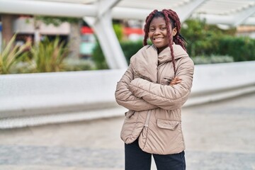 African american woman standing with arms crossed gesture at park