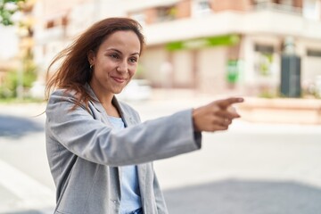 Fototapeta premium Young woman executive pointing with finger at street