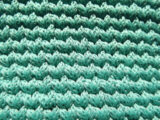 Background turquoise,sea-green, blue crocheted stripes of polyester cord
