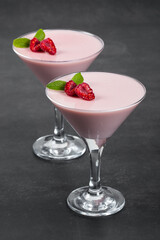 Vegan dessert. Raspberry cream jelly, Panna Cotta in a martini glass. Dark background