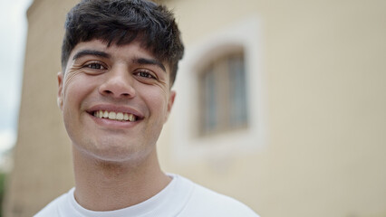 Young hispanic man smiling confident standing at street