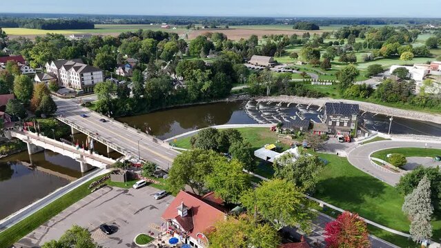 A forward aerial establishing shot view of the tourist district of Frankenmuth Michigan with the Cass River and the "Willkommen" welcome sign in the distance.  	