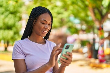 African american woman smiling confident using smartphone at park