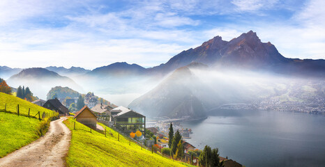 Gorgeous autumn view on suburb of Stansstad city and Lucerne lake with mountaines and fog