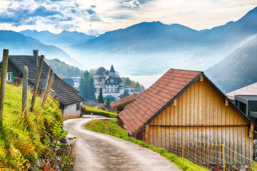 Captivating autumn view on suburb of Stansstad city and Lucerne lake with mountaines and fog