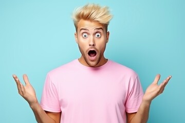 surprised and excited young blond man is wearing a pink t-shirt