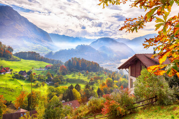 Exciting autumn view on suburb of Stansstad city and Lucerne lake with mountaines and fog - obrazy, fototapety, plakaty