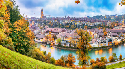 Fabulous autumn view of Bern city on  Aare river during evening with Cathedral of Bern on background.