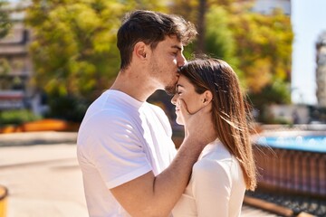 Mand and woman couple hugging each other and kissing at park