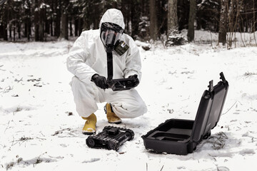 Two dosimetrist in protective suite and mask with geiger counter measuring radiation level in...