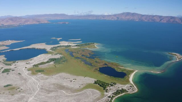 Drone footage of Sevan Lake and Norashen Natural Reserve on sunny summer day. Gegharkunik Province, Armenia.