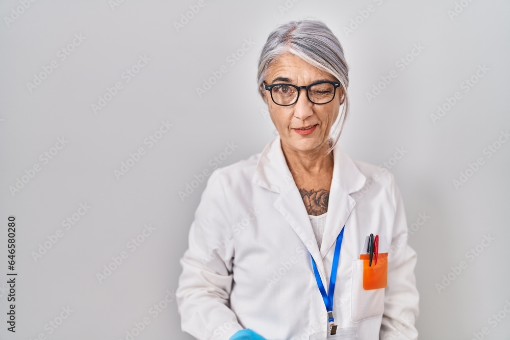 Sticker middle age woman with grey hair wearing scientist robe winking looking at the camera with sexy expre