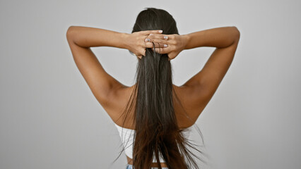 Young latin woman touching her hair backwards over isolated white background