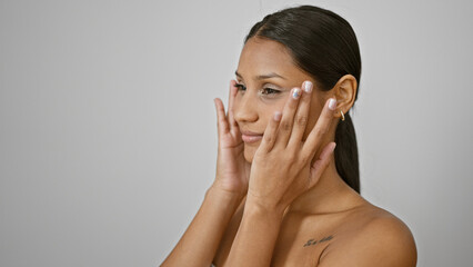 Young latin woman touching skin face over isolated white background
