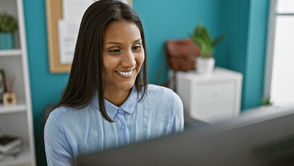 Young latin woman business worker using computer working at the office