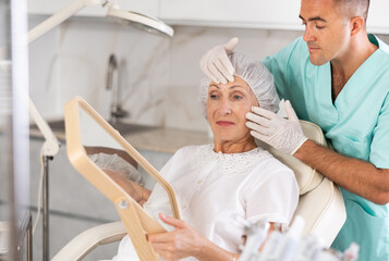 Having concluded treatment, male physician reveals results to satisfied female patient.