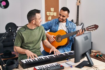 Two men musicians playing piano and classical guitar at music studio - Powered by Adobe