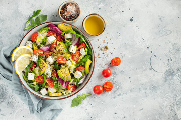 Delicious and healthy green salad of different leaves and vegetables with seeds and olive oil.