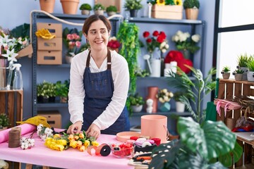 Young woman florist make bouquet of flowers at florist shop