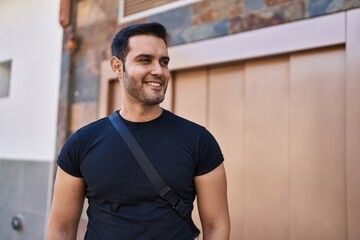 Young hispanic man smiling confident standing at street