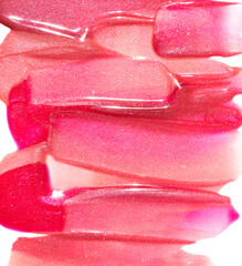 Pink red gold lip gloss texture composition on white background. Cosmetic product smear smudge...