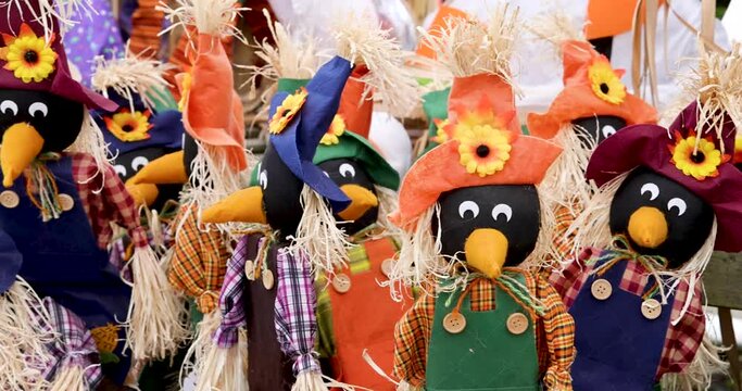 Close up view of colorful scarecrows up for sale in autumn time.