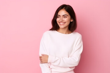 Fototapeta premium Beautiful brunette woman wearing white sweatshirt mockup in studio against pink background, young woman wearing white sweatshirt mockup. Print presentation mock-up
