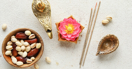 Diya lamp with lotus flower and treats for Indian holiday Diwali (Festival of lights) on light background