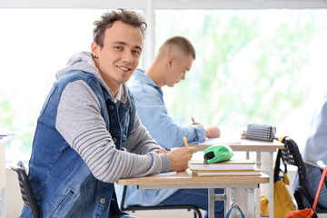 Obraz premium Happy male student sitting with his classmates in classroom