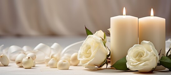 Cream-colored candles and flowers with a satin background in an elegant home interior arrangement for a wedding card.