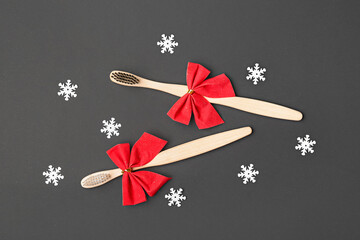 Toothbrushes with bows and snowflakes on black background