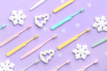 Toothbrushes with Christmas decor on lilac background
