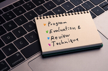 There is notebook with the word Program Evaluation and Review Technique. It is as an eye-catching image.