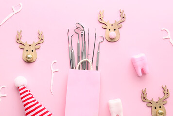 Bag with dental tools and Christmas decor on pink background