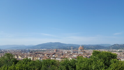 Fototapeta na wymiar View of Florence, Italy, with majestic mountains looming in the distance, their peaks shrouded in a veil of mist.