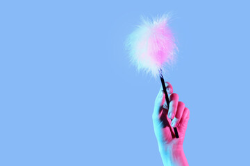 Woman with feather stick from sex shop on color background