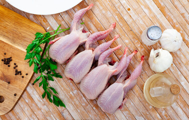 Fresh raw meat quails ready for cooking on the slate board