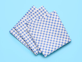 Set of checkered napkins on color background