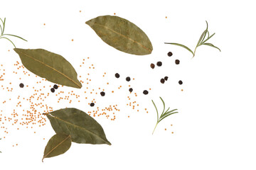 Flying peppercorns, mustard seeds and bay leaves on white background