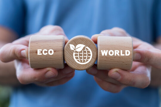 Man holding wooden cylinders sees text: ECO WORLD. Concept of world ecology, nature global protection. Green earth planet. Eco environment. ESG, Renewable and Sustainable Resources. Environmental Care