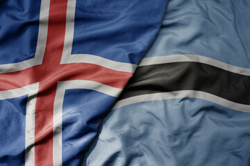 big waving national colorful flag of icelandic and national flag of botswana .