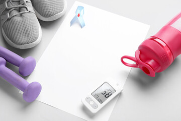 Blank paper with glucometer, awareness ribbon and sports equipment on light background. Diabetes concept