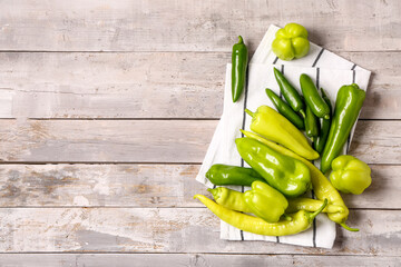Different fresh peppers on grey wooden background