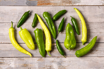 Different fresh peppers on grey wooden background