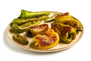 Plate with different grilled peppers on white background