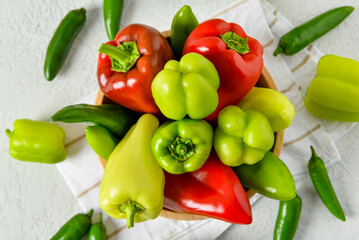 Wooden bowl with different fresh peppers on white background