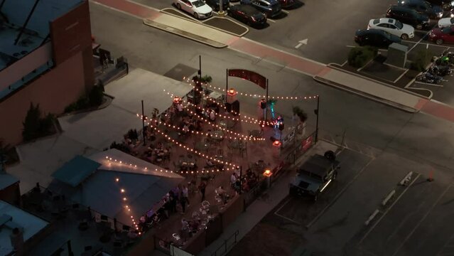 People sitting and eating together at Outdoor restaurant. aerial top view at night time